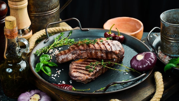 Gegrilde ribeye beef steak kruiden en specerijen op een donkere tafel Bovenaanzicht Vrije ruimte voor uw tekst