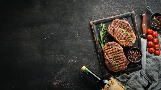 Gegrilde ribeye beef steak kruiden en specerijen op een donkere tafel Bovenaanzicht Vrije ruimte voor uw tekst