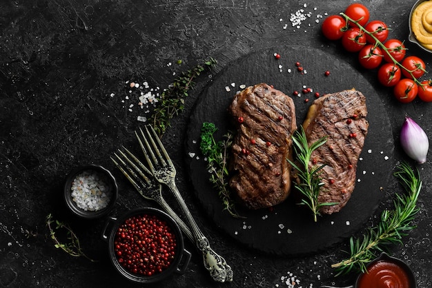 Gegrilde ribeye beef steak kruiden en specerijen op een donkere tafel Bovenaanzicht