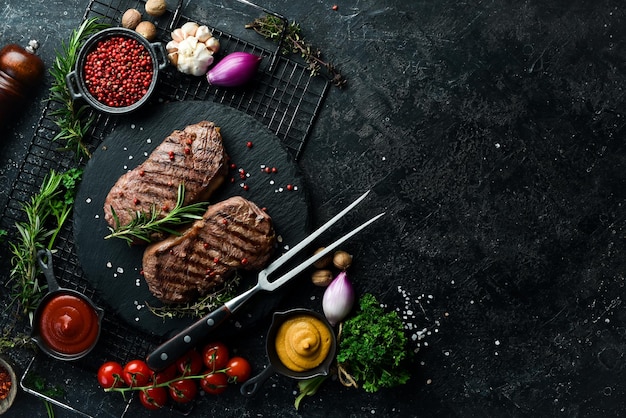 Gegrilde ribeye beef steak kruiden en specerijen op een donkere tafel Bovenaanzicht