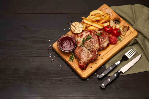 Gegrilde rosbief steaks aardappel en saus op houten snijplank