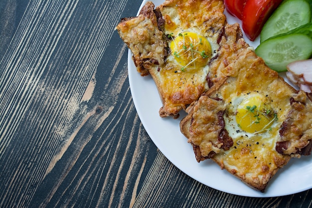 Gegrilde sandwich met ei, groenten en spek op een donkere houten achtergrond