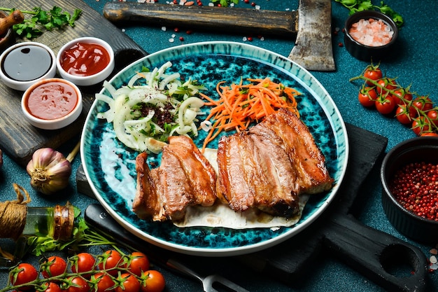 Gegrilde sappige varkensribbetjes met uien en pitabroodje Barbecuemenu Vrije ruimte voor tekst Close-up