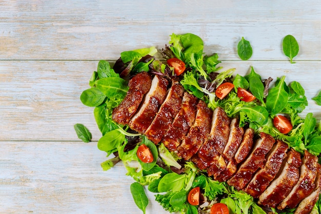 Gegrilde spareribs met groene salade.