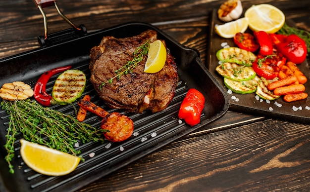 gegrilde steak in een pan met kruiden en gegrilde groenten op hout! heerlijk diner