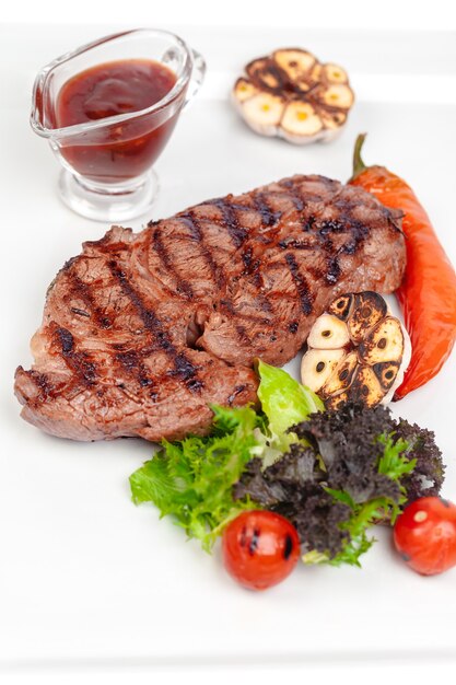 Gegrilde steak met groenten en saus op wit close-up