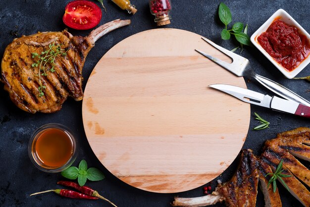 Foto gegrilde t-bone steak op stenen tafel met houten plank.