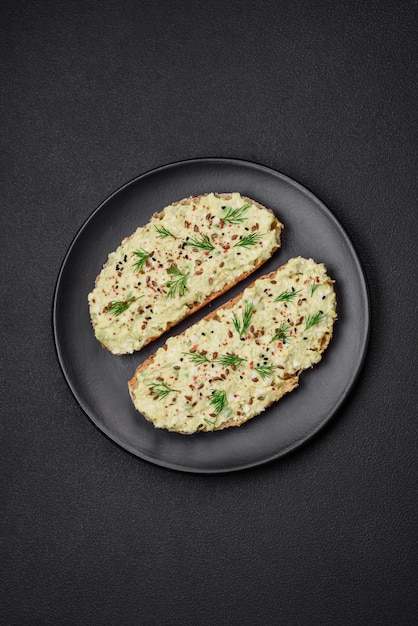 Gegrilde toast met avocadopasta, eieren, roomkaas, zout, specerijen en kruiden