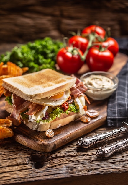 Gegrilde toast met bacon en zonnige kant naar boven met pittige aardappelpartjes en saus aan de zijkant.