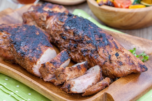 Gegrilde varkenshaas geserveerd op een houten bord