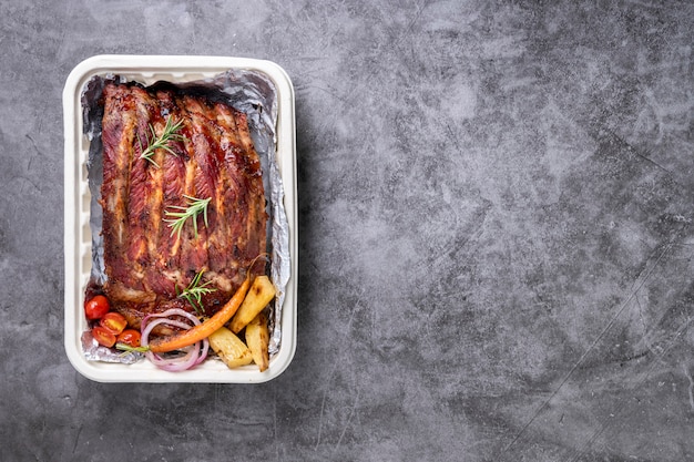 Gegrilde varkensribbetjes met groenten en sauzen op een drak tafel