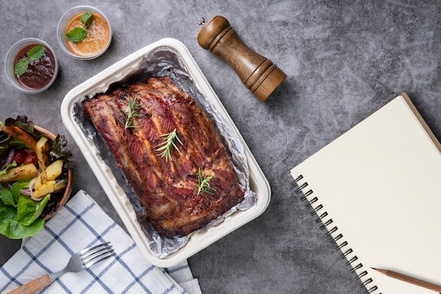 Gegrilde varkensribbetjes met groenten en sauzen op een drak tafel