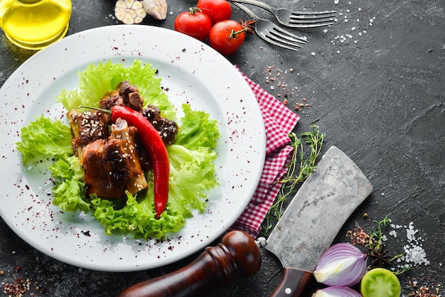 Gegrilde varkensribbetjes met saus en groenten op een bord bovenaanzicht gratis kopieerruimte