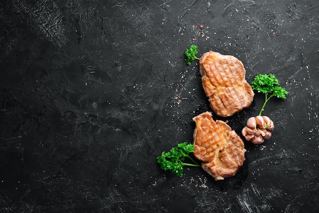 Gegrilde varkenssteak met specerijen en kruiden Bovenaanzicht Vrije ruimte voor uw tekst