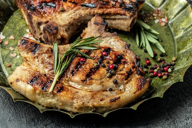 Gegrilde varkenssteak op het bot met kruiden en tomaten Voedselrecept achtergrond Close-up bovenaanzicht