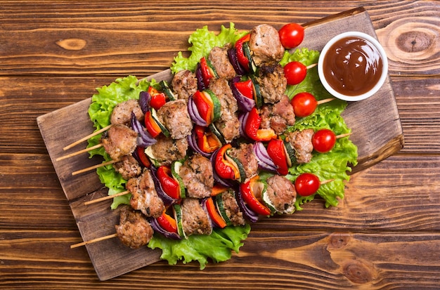 Gegrilde varkensvlees shish of kebab op spiesjes met groenten Voedsel achtergrond shashlik