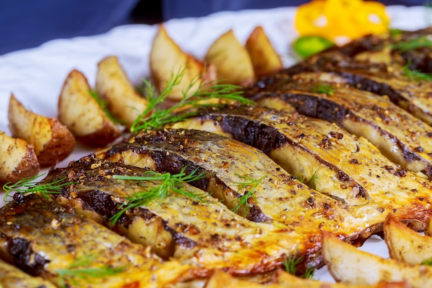 Gegrilde vis met geroosterde aardappelen en groenten op de plaat