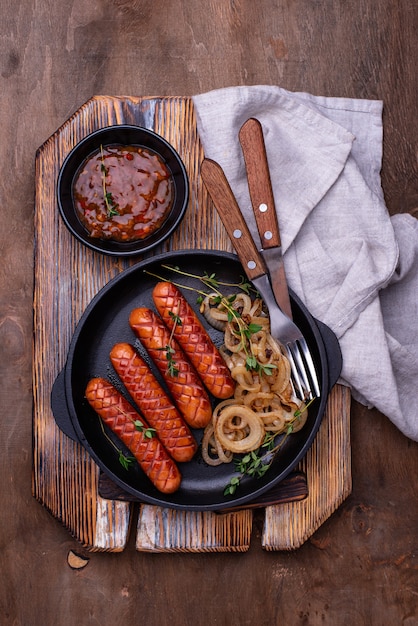 Gegrilde worstjes met geroosterde ui en chilisaus