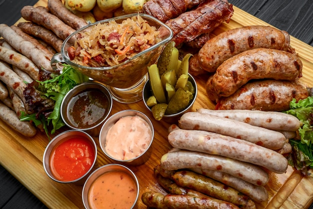 Gegrilde worstjes met glas bier op een houten tafel