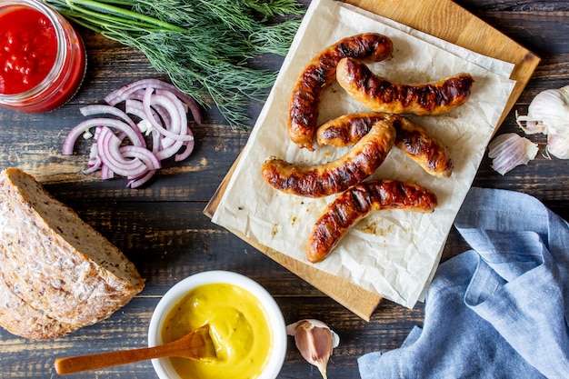 Gegrilde worstjes met mosterd. Ui. Brood. Duitse keuken.