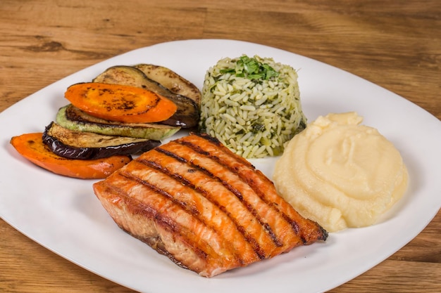 Gegrilde zalm met aardappelpuree en broccolirijst en gegrilde groenten geserveerd in een restaurant