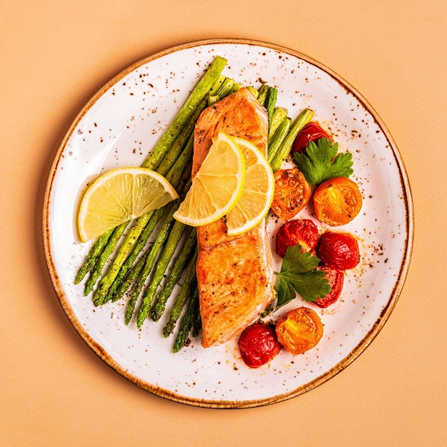 Gegrilde zalm met asperges en tomaten, bovenaanzicht.