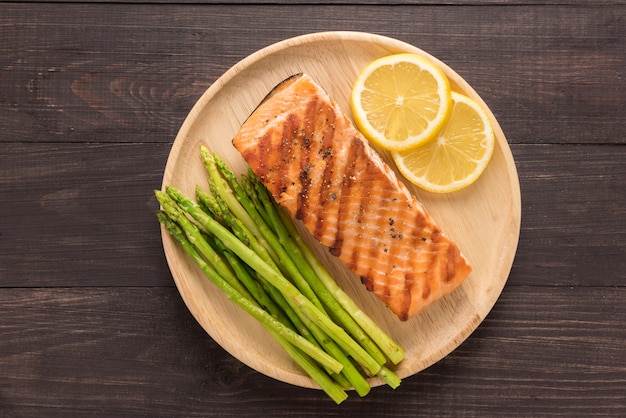 Gegrilde zalm met citroen, asperges op de houten achtergrond