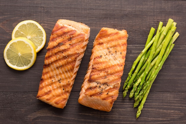 Gegrilde zalm met citroen, asperges op de houten achtergrond