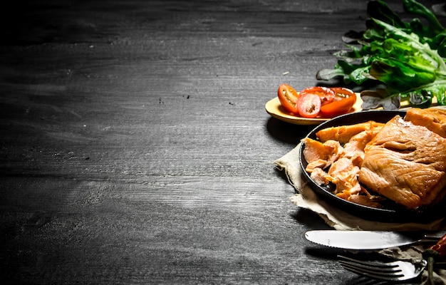 Foto gegrilde zalm met tomaten en kruiden.