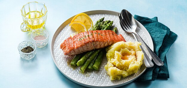 Gegrilde zalm met verse asperges en aardappelpuree op een bord. gezonde voeding op tafel