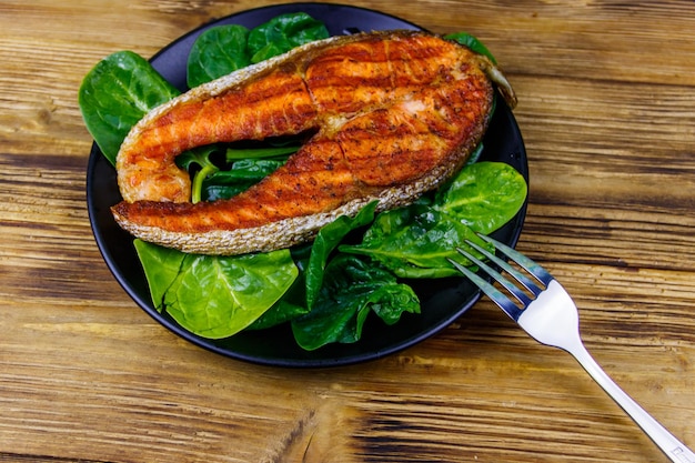 Gegrilde zalm steak met spinazie op houten tafel bovenaanzicht