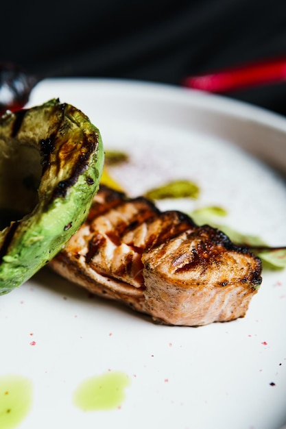 Gegrilde zalm visfilet met groenten en avocado op de plaat close-up