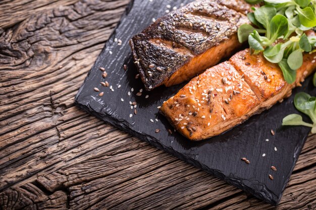 Gegrilde zalmfilets met kruiden op leistenen bord