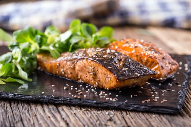 Gegrilde zalmfilets met kruiden op leistenen bord