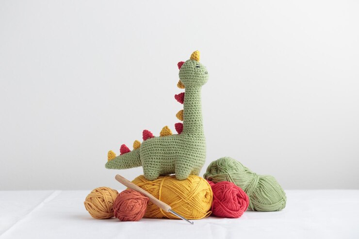 Gehaakte Cute Green Dinosaur met een draad op een witte achtergrond met een copyspace