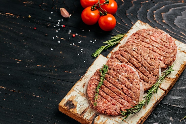 Gehakt vlees voor hamburger, rundvlees lamsvlees Burger steak schnitzels op zwarte achtergrond. Bovenaanzicht.