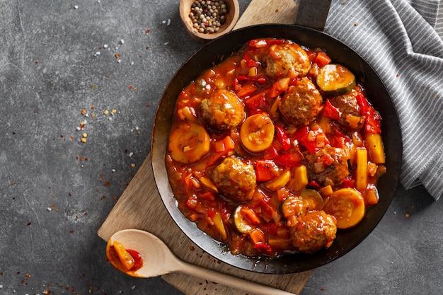 Gehaktballen met groenten en saus gemaakt in de pan en geserveerd op tafel.