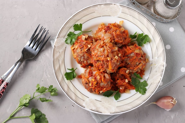 Gehaktballen met rijst en gehakt in tomatensaus in plaat op lichtgrijze achtergrond, horizontaal formaat, weergave van bovenaf