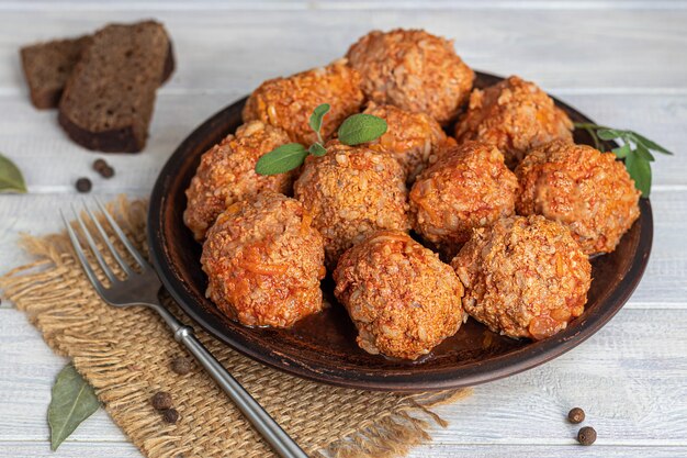 Gehaktballen op een lichte achtergrond met salie en peterselie bladeren. Zelfgemaakte lunch.