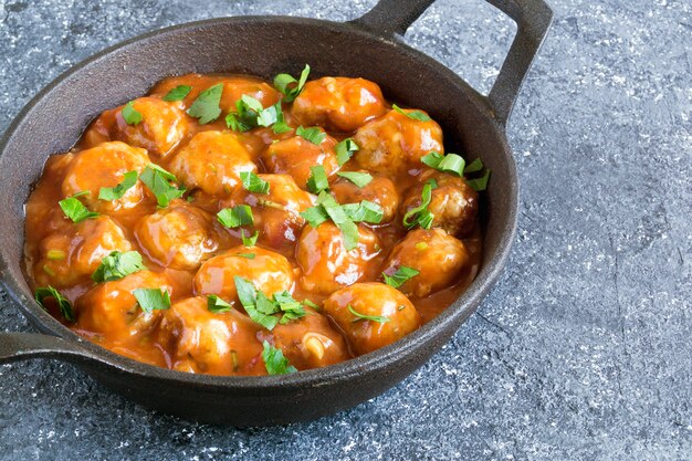 Gehaktballetjes in zoetzure tomatensaus met kruiden.