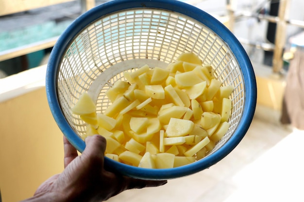 Gehakte aardappelstukjes in een plastic mand