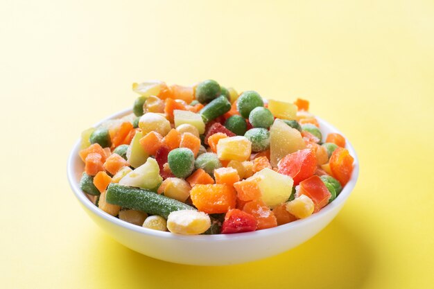 Gehakte bevroren groenten in een plaat. Maïs erwten peper wortelen. kopieer ruimte.