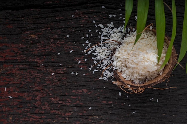 Gehakte kokosnoot op een houten ondergrond, bovenaanzicht. Kokosmelk en kokosvlokken zijn tropische voedingsmiddelen