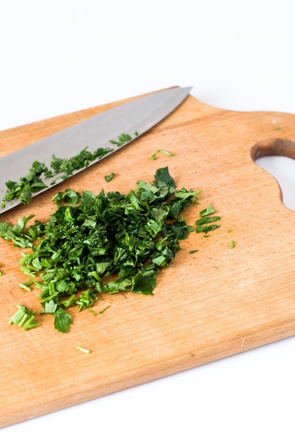 Gehakte rucola en mes op een houten bord geïsoleerde witte background