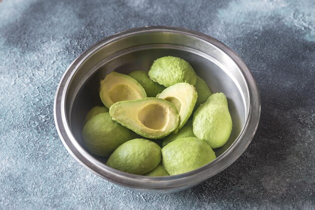 Gehalveerde avocado's in de metalen kom