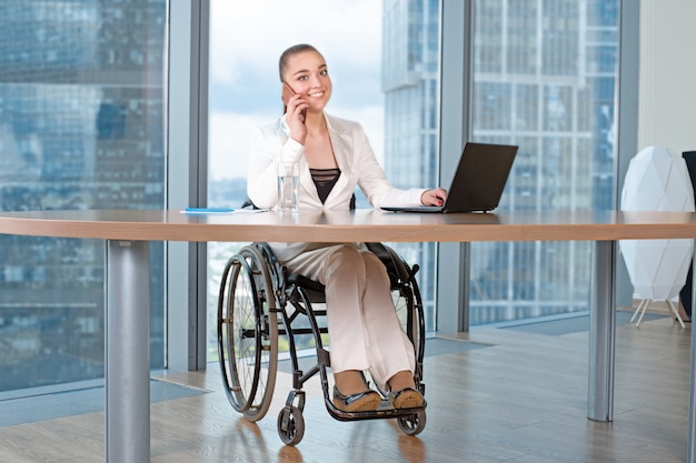 Gehandicapte jonge bedrijfsvrouw die in bureau werkt