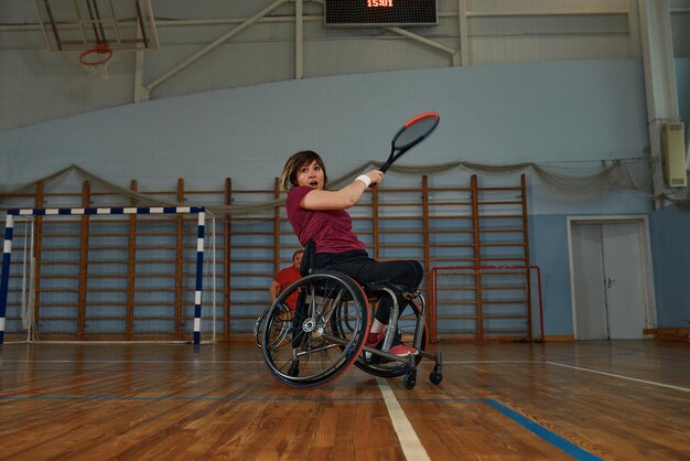 Gehandicapte jonge vrouw op rolstoel tennissen op tennisbaan