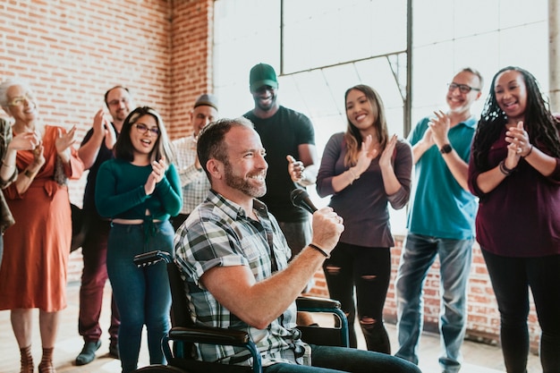 Gehandicapte man die op een microfoon spreekt in een workshop