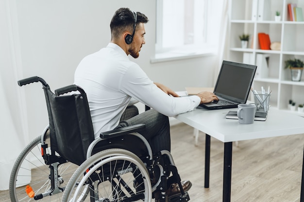 Gehandicapte man in een rolstoel met laptop close-up