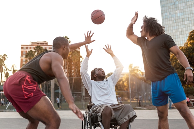 Gehandicapte man in rolstoel die basketbal speelt met zijn vrienden